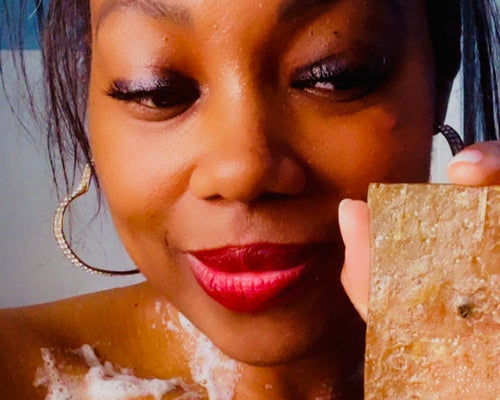 Woman with soap bar and bubbles, likely in a bathroom setting